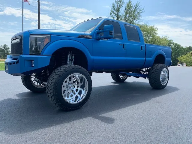 Matte blue lifted Ford Super Duty on polished forged wheels built by Midwest Custom Trucks