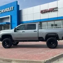 Lifted gray Chevrolet Silverado on black wheels