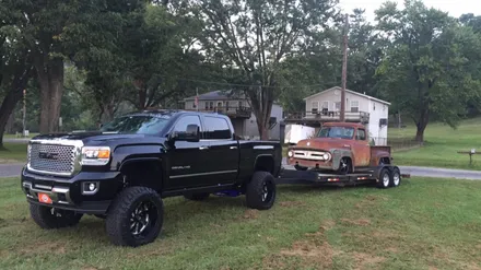 Lifted GMC hauling a project truck