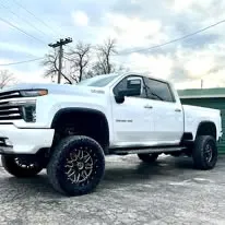 Lifted white Chevrolet Silverado HD on custom wheels by Midwest Custom Trucks
